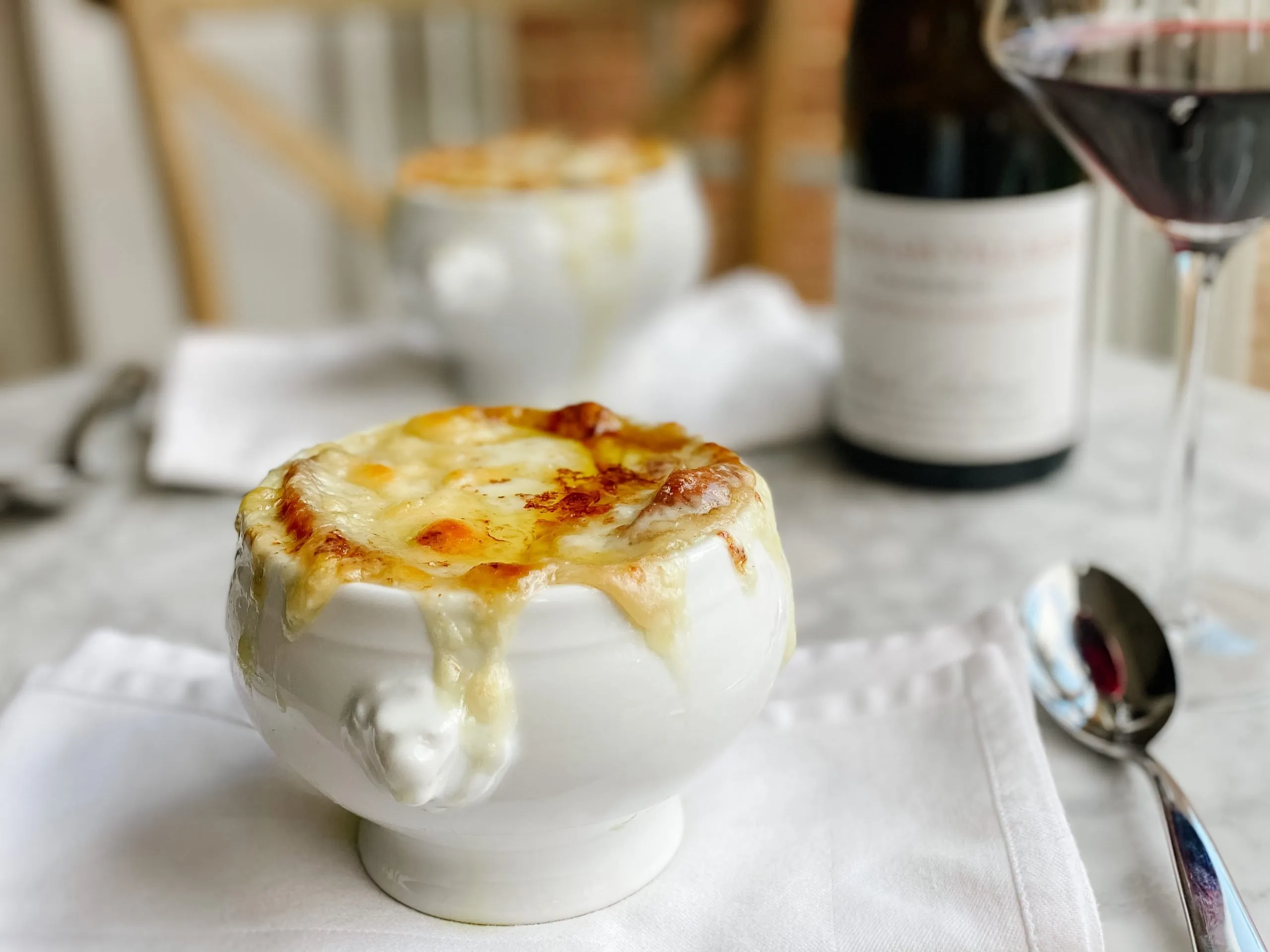 french onion Soup recipe in a white bowl with wine