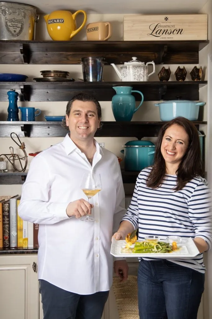 Le Chef Sebastien and Le Chef's Wife stand in their kitchen with the dish of French Spring Asparagus