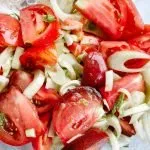 tomatoes and sliced fennel in a clear bowl