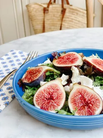 fresh figs salad with goat cheese on a blue plate