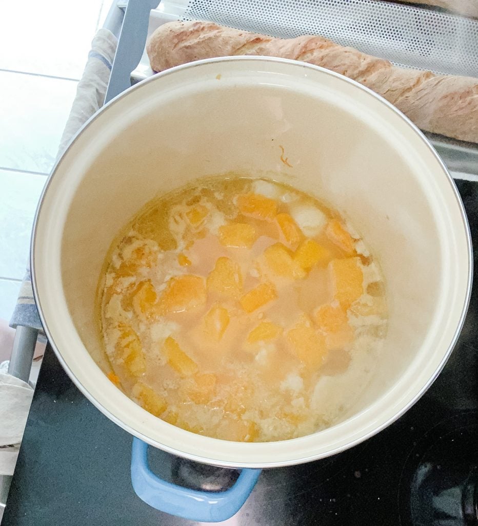 cooking butternut squash and potatoes for soup in a soup pot