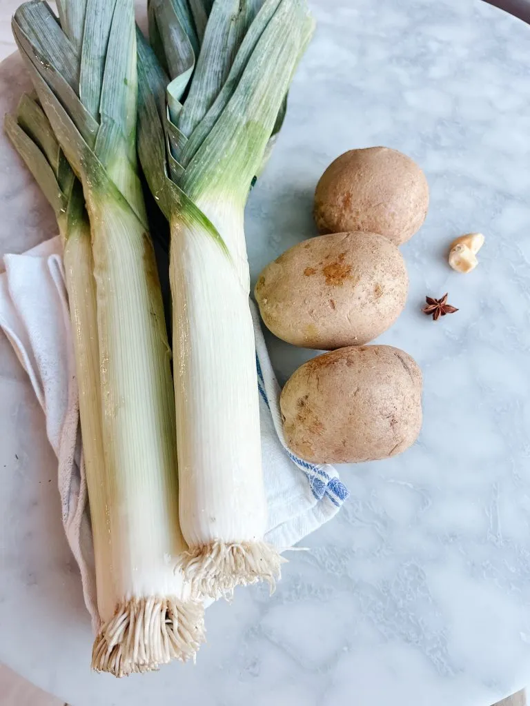 leeks on a table with potatoes and star anis seed
