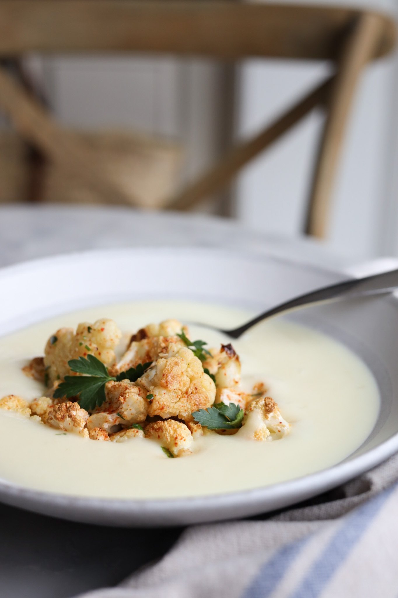 Fancy cream of cauliflower soup in a bowl with roasted cauliflower