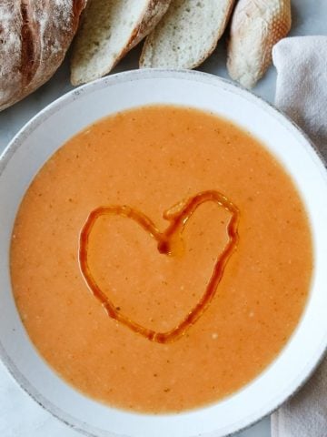 La Soupe de Mamie vegetable soup with an olive oil heart drizzled on top and a fresh baked baguette