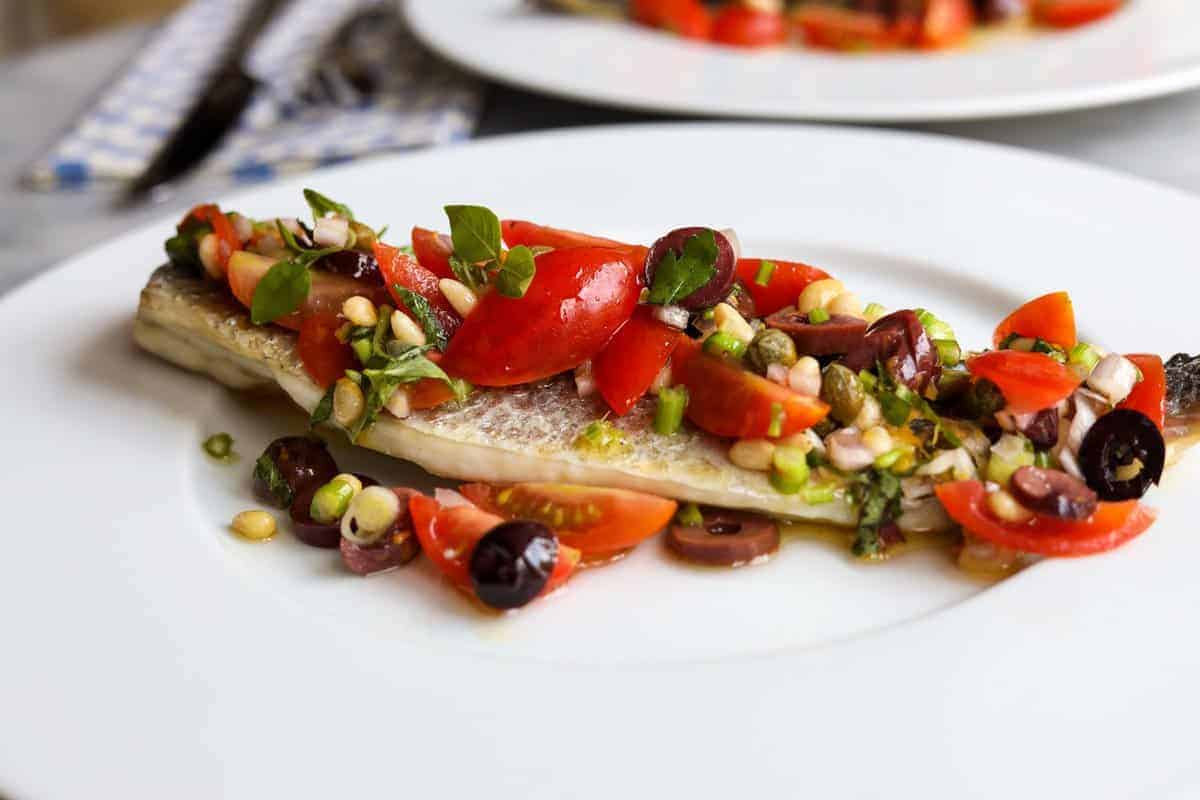 branzino filet topped with tomatoes, olives, pinenuts and basil