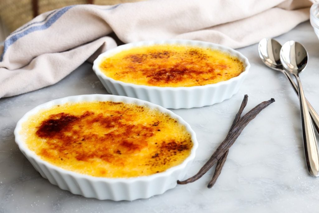 Crème Brulée on a table ready to eat with two spoons