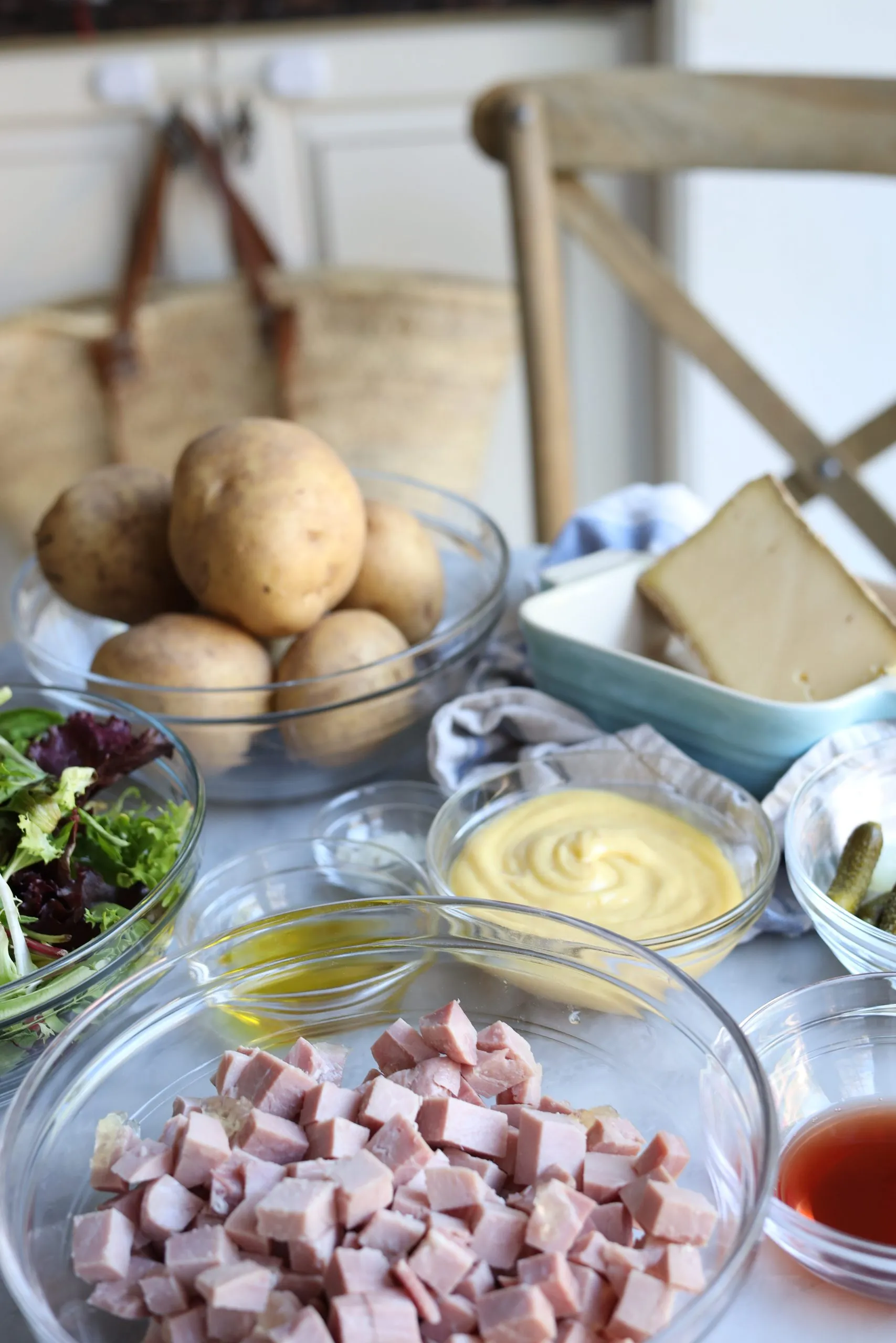 Ingredients for la salade parisienne - potatoes, ham, gherkins, olive oil, vinegar and comte cheese