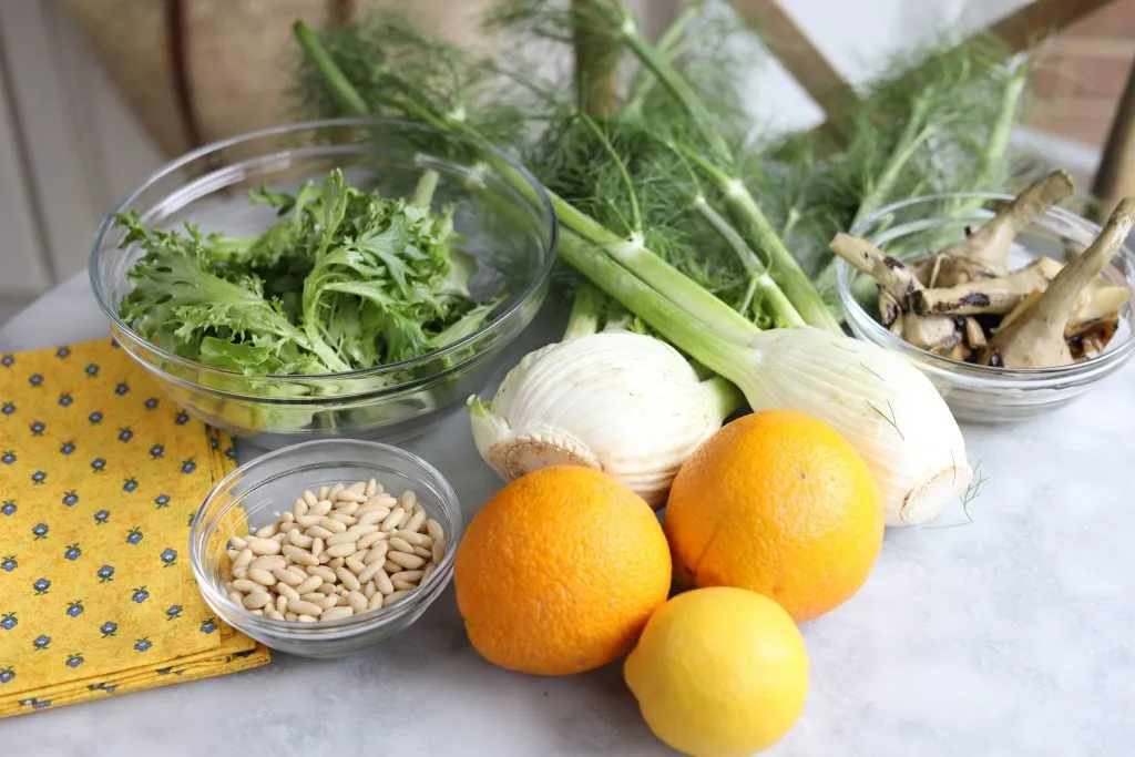 ingredients for la salade mentonnaise : fennel, oranges, pine nuts, artichokes and greens