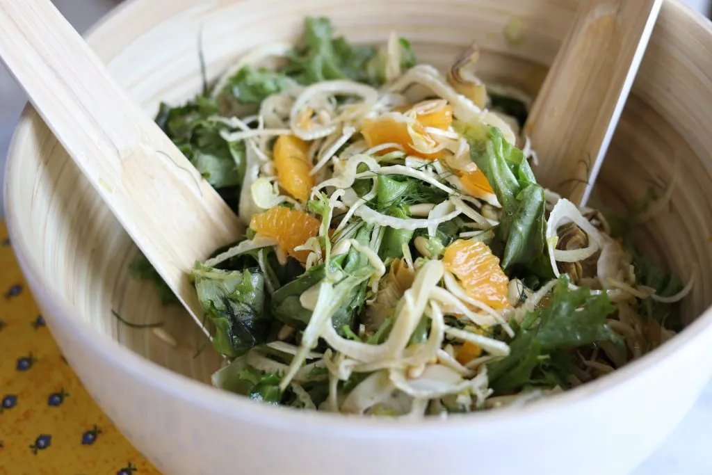 la salade mentonnaise : fennel, oranges, pine nuts, artichokes and greens in a serving bowl