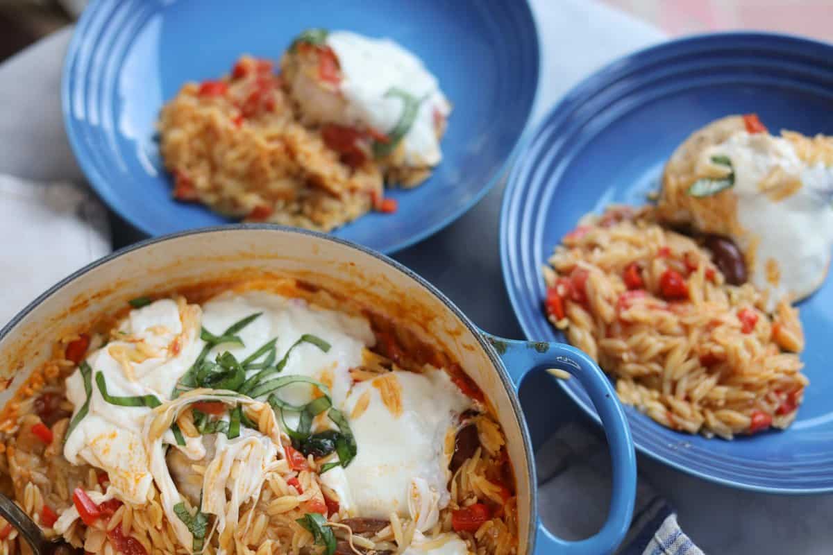 a pot of cheesy chicken and orzo pasta with two side dishes