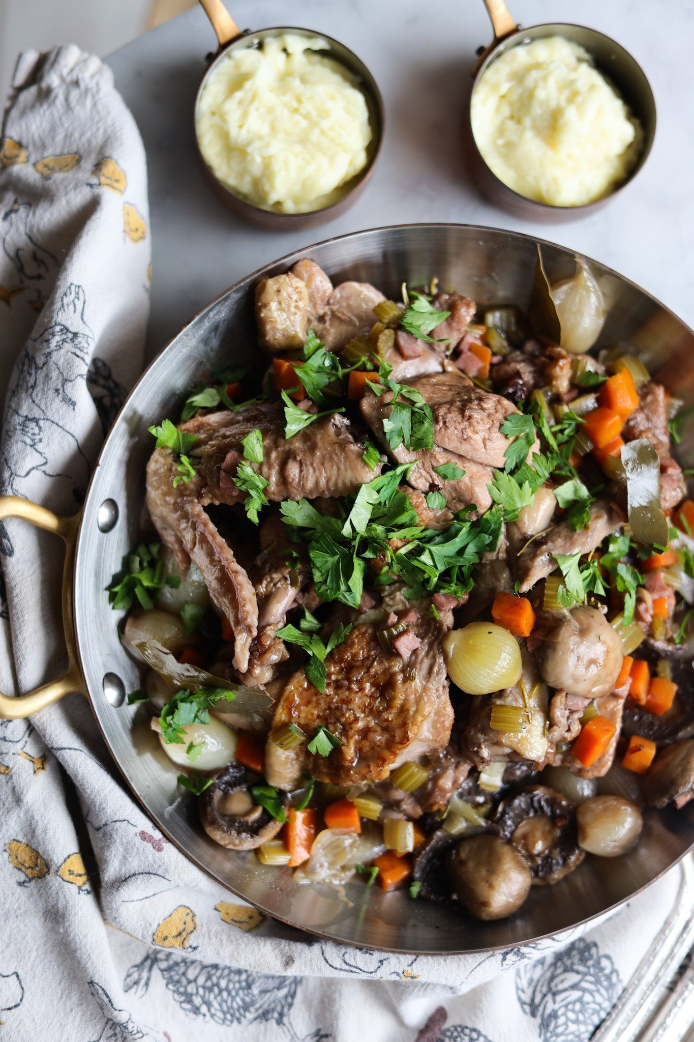 Coq au Vin with mushrooms, chicken, onions and parsley served with mashed potatoes