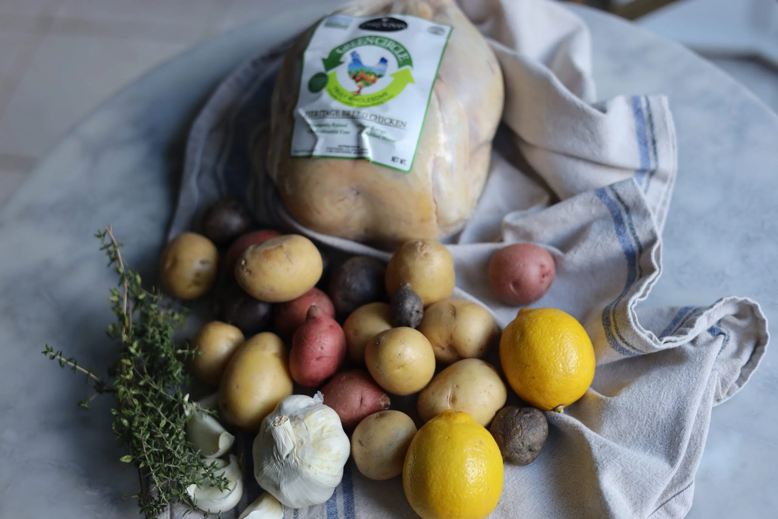 ingredients for poulet roti- chicken, potatoes, garlic, lemon and thyme