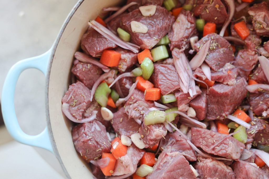 beef bourguignon ready to marinade with wine, carrots, celery and garlic