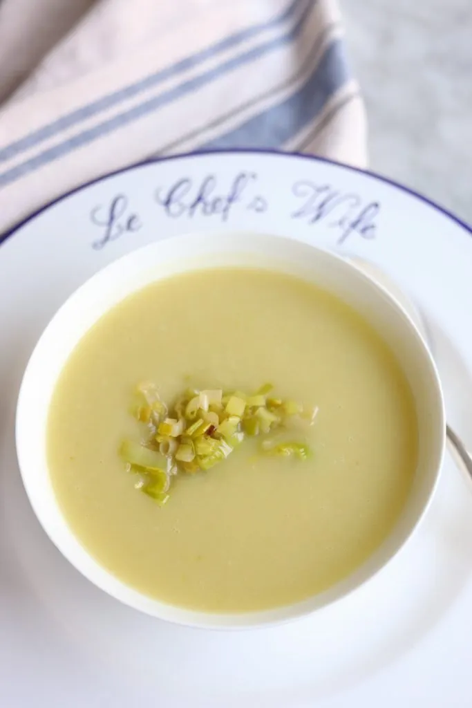 a bowl of leek soup with sauteed leeks as a garnish