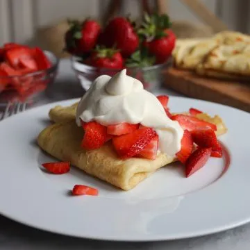 Chantilly cream over strawberry crepes