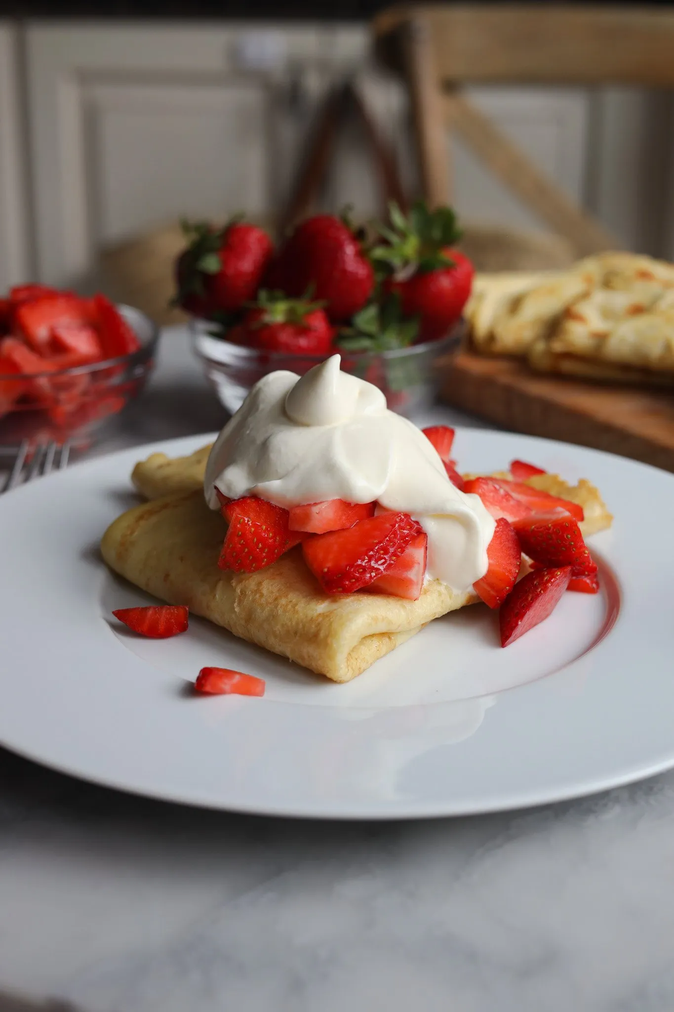 Chantilly cream over strawberry crepes