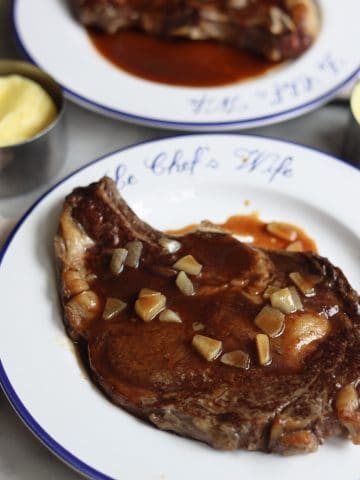 Wagyu rib eye steak on a plate with demi glace sauce