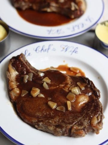 Wagyu rib eye steak on a plate with demi glace sauce