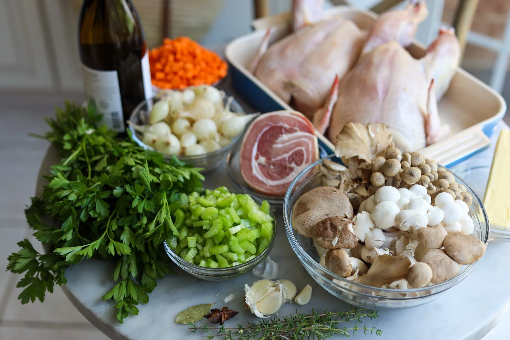 Ingredients for coq au vin blanc - chicken, white wine, pork belly, celery, onions, mushrooms, parsley