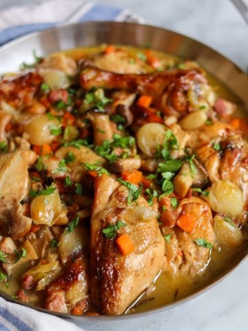 coq au vin blanc , a chicken stew with white wine, pork belly, celery, onions, mushrooms, parsley