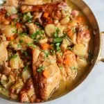 coq au vin blanc , a chicken stew with white wine, pork belly, celery, onions, mushrooms, parsley