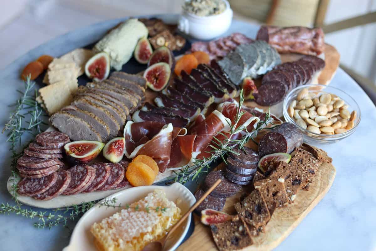 french charcuterie board with a mix of nuts and cheeses arranged on a platter