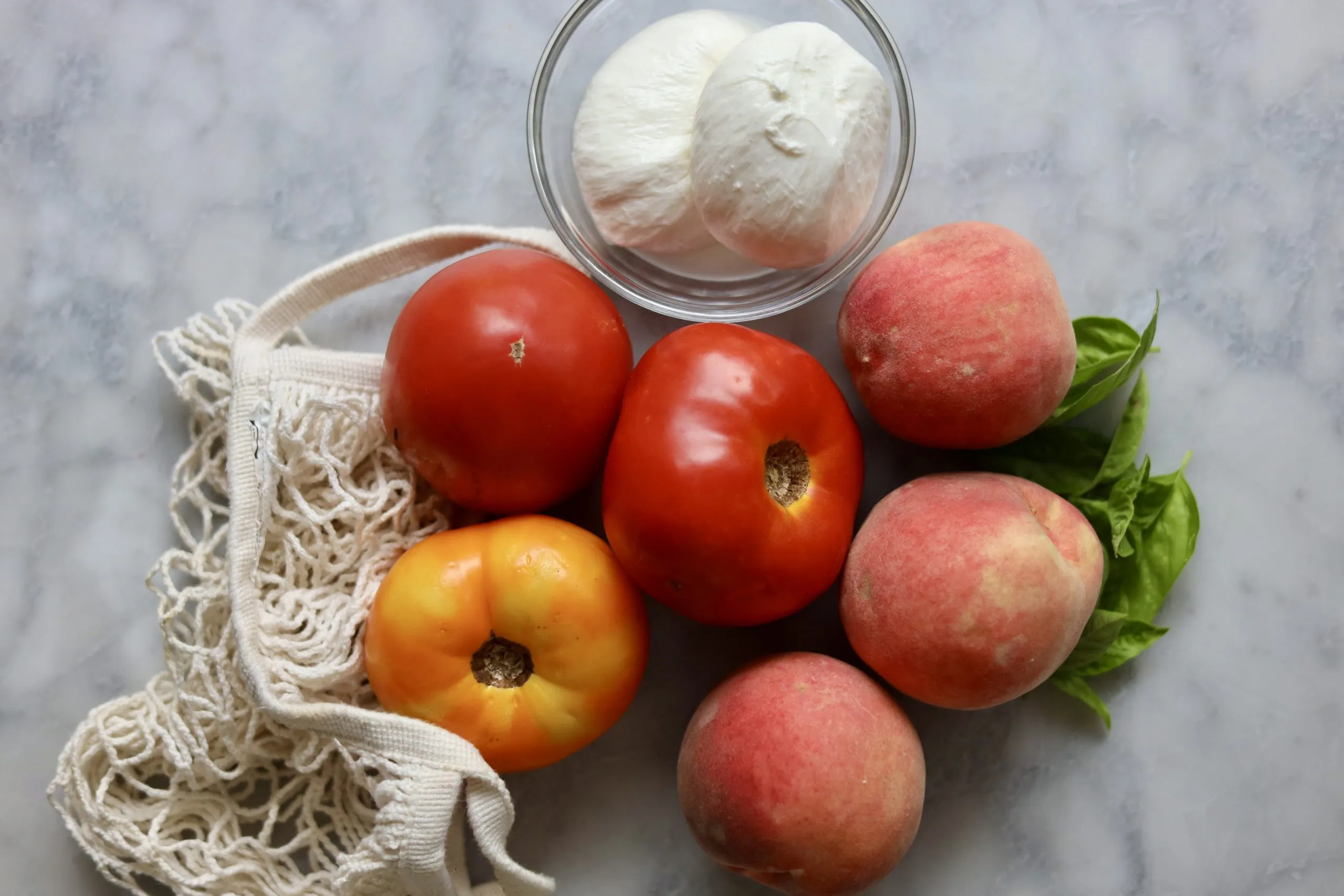 Peach caprese salad with peaches, tomatoes, burrata and basil