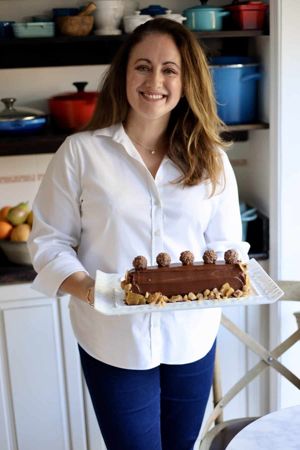 the author, le chefs wife in her kitchen holding a nutella buche de notel