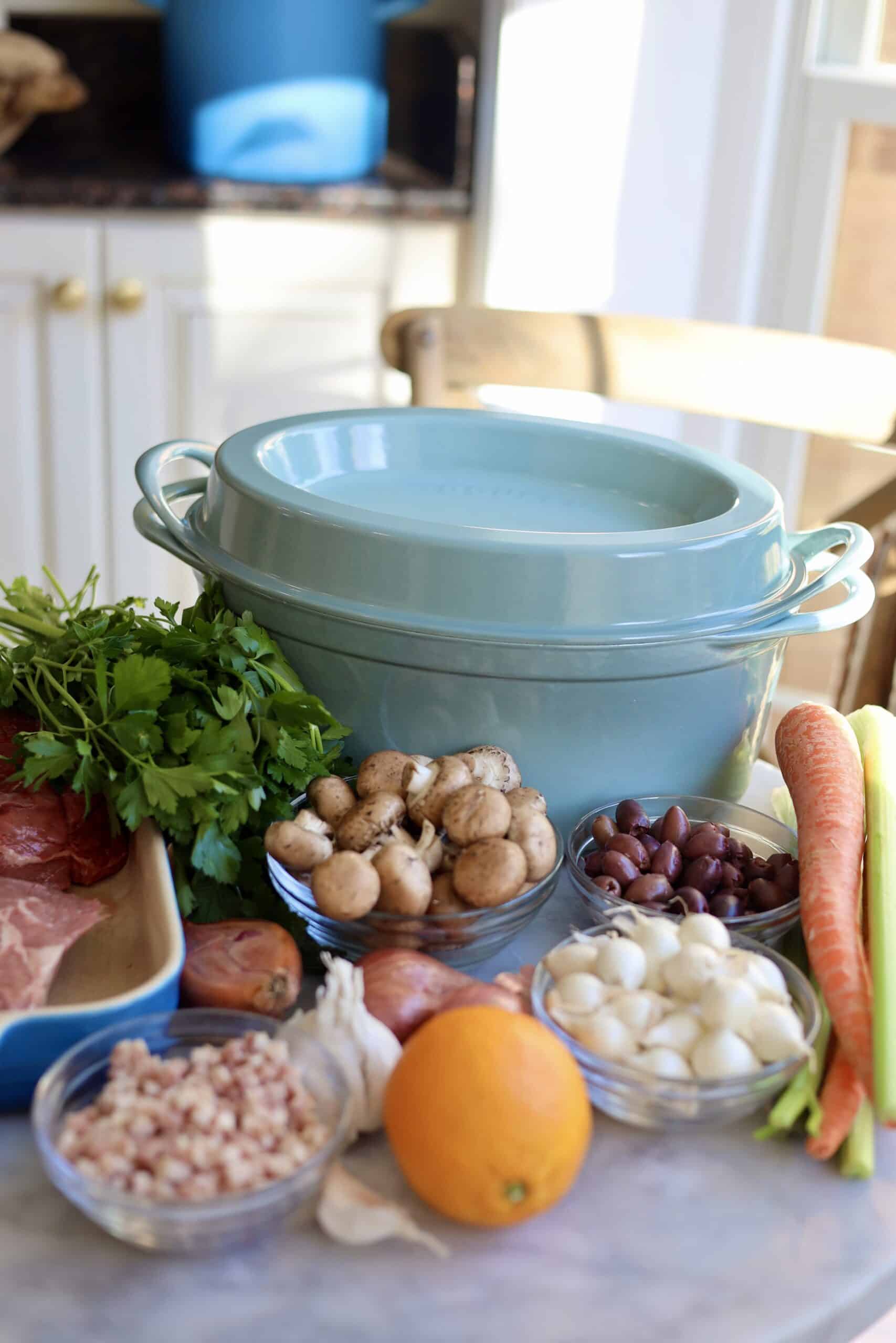 le creuset dutch oven with the ingredients for boeuf bourguignon in front of it