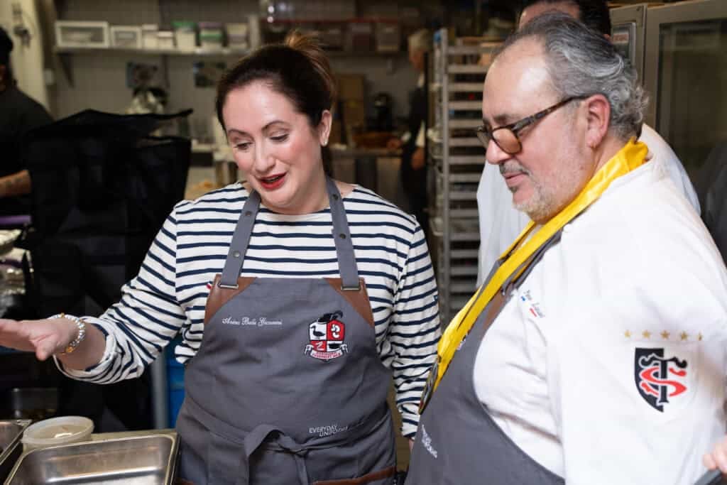 Le Chefs wife anina belle gainnini at the Cassoulet War competition explaining her dish to Pierre Landet