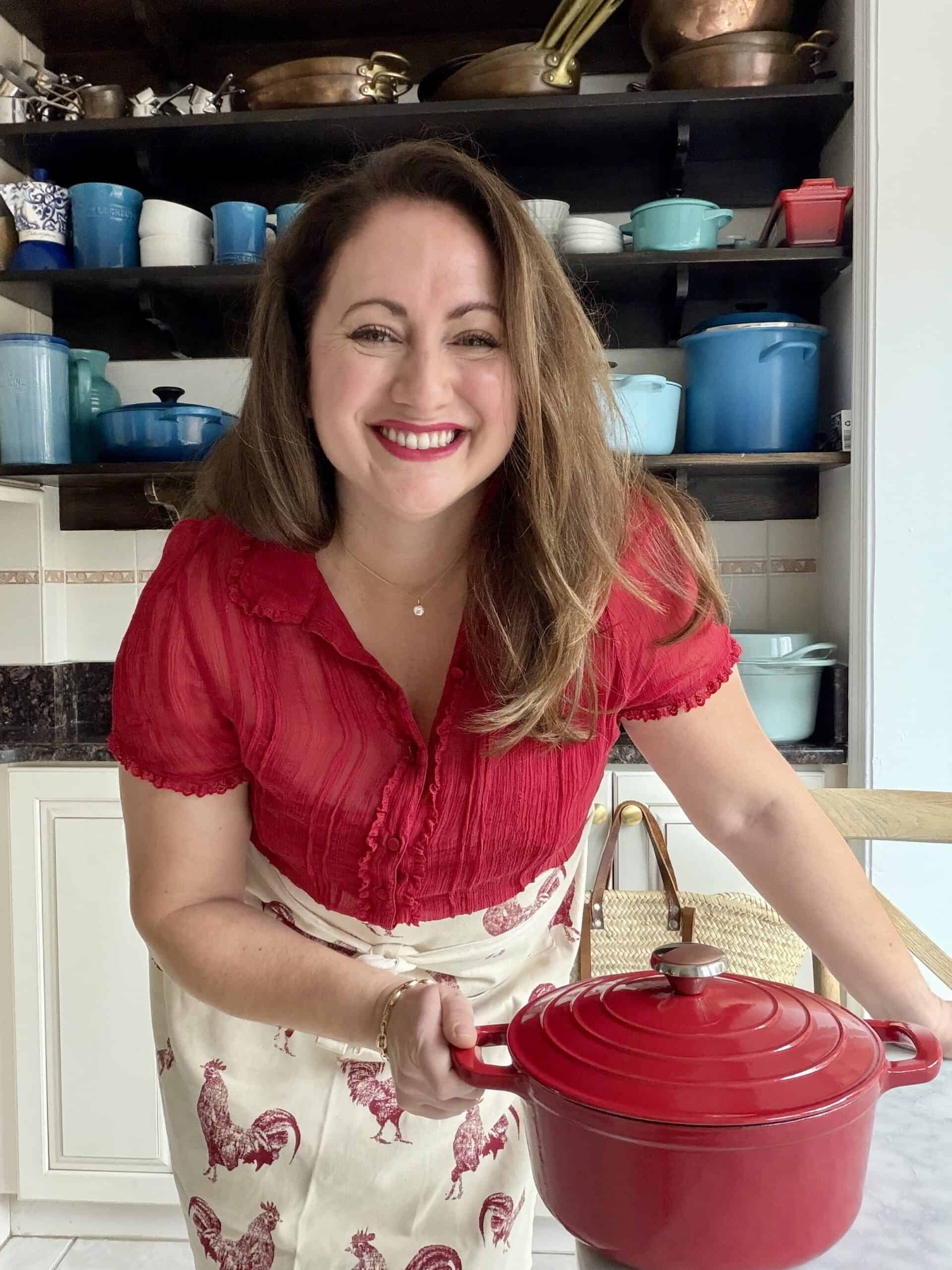 le chefs wife in front of a wall of dutch ovens