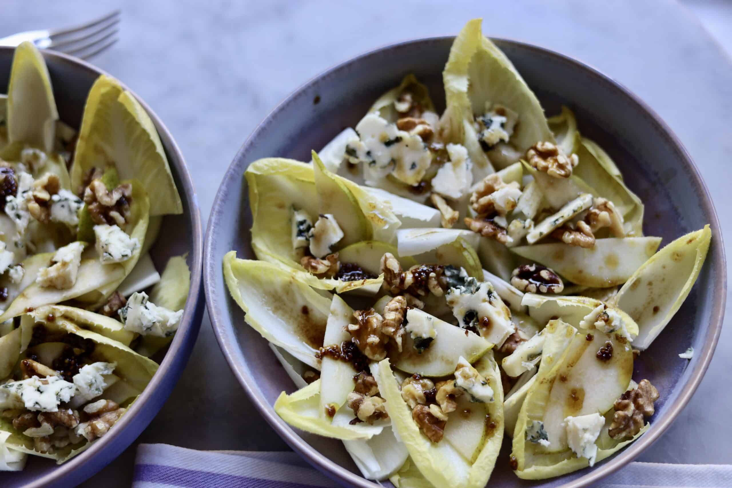 close up of classic endive salad with blue cheese, endives, walnuts, pears and dijon mustard