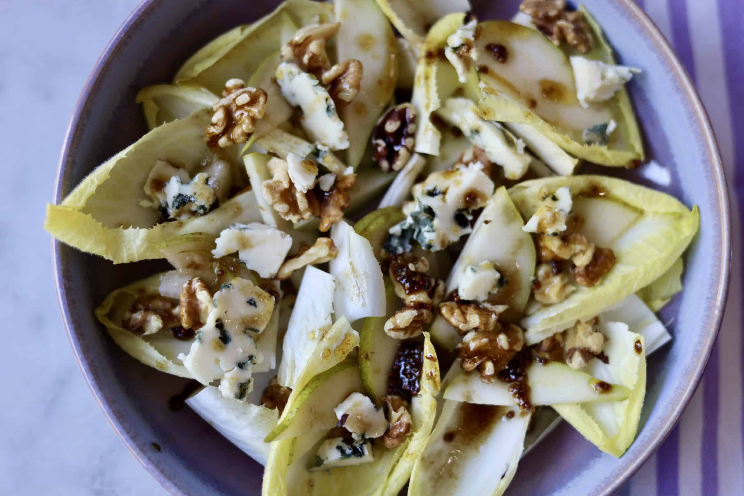 close up of classic endive salad with blue cheese, endives, walnuts, pears and dijon mustard