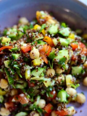 gluten-free quinoa tabbouleh with cucumbers, peppers and chick peas in a bowl