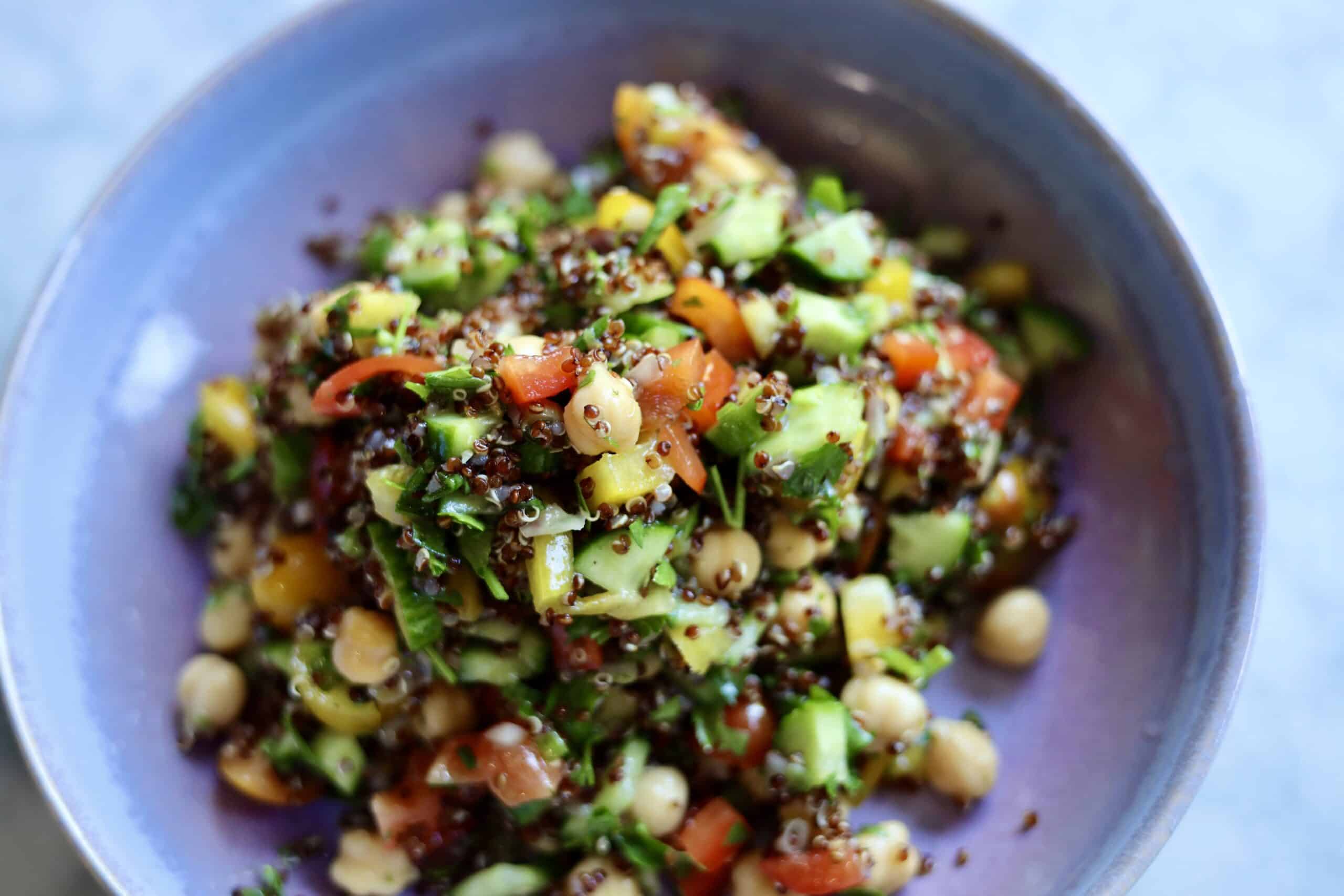 gluten-free quinoa tabbouleh with cucumbers, peppers and chick peas in a bowl