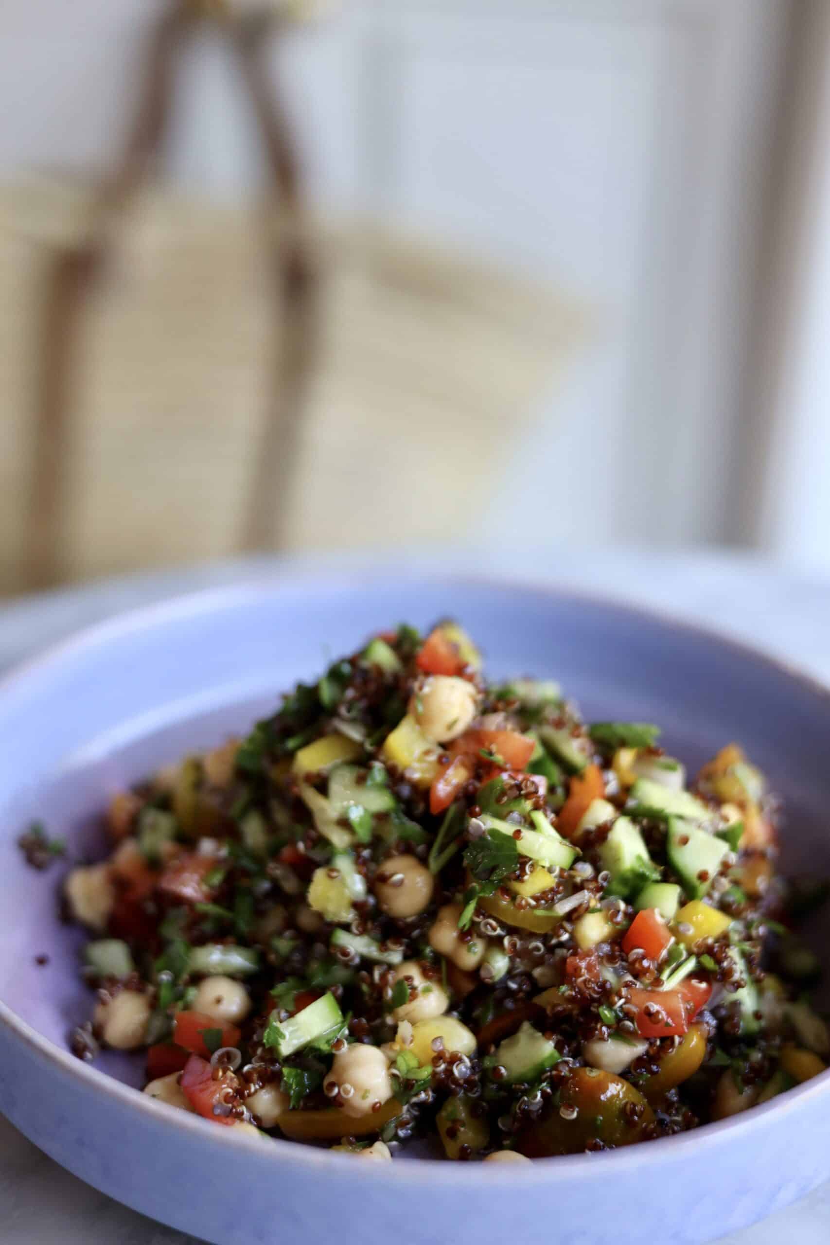 gluten-free quinoa tabbouleh with cucumbers, peppers and chick peas in a bowl