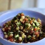 gluten-free quinoa tabbouleh with cucumbers, peppers and chick peas in a bowl