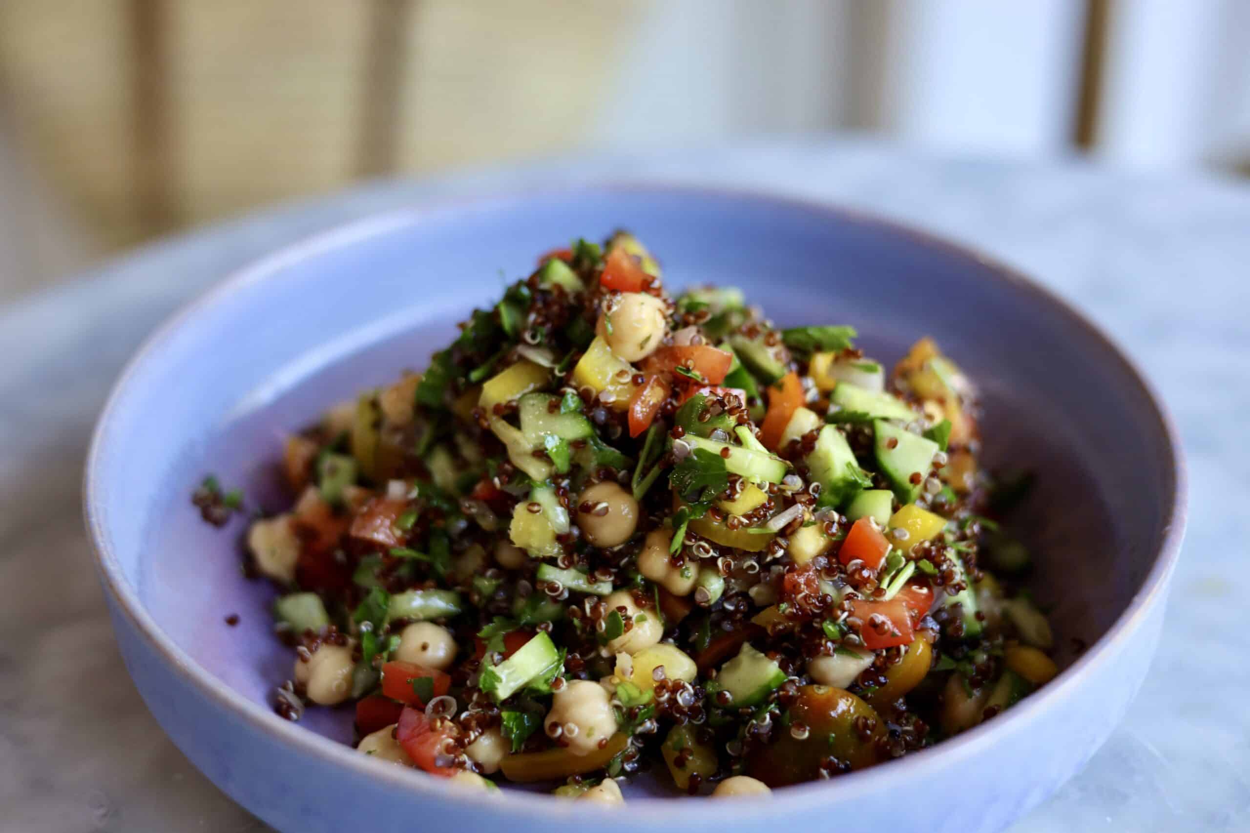 gluten-free quinoa tabbouleh with cucumbers, peppers and chick peas in a bowl
