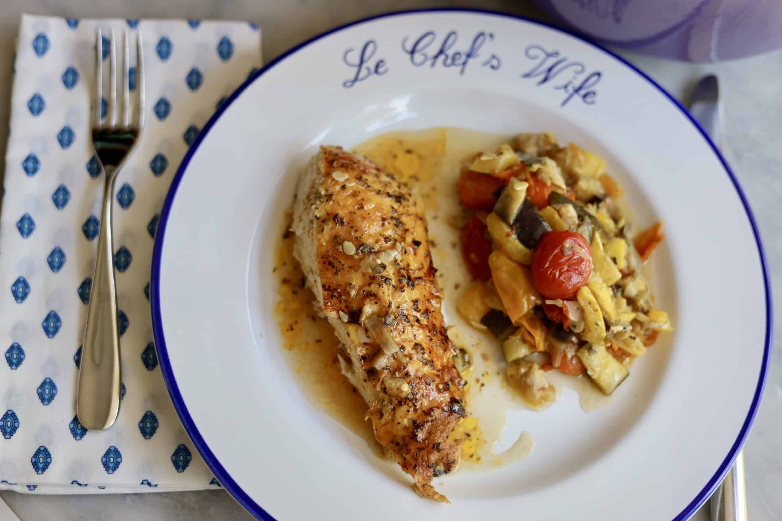 Provencal roast chicken ratatouille on a plate - the choped vegetables and herbs for the ratatouille on the bottom - fresh out of the oven- the skin is crispy